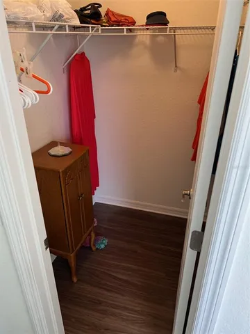 a view of a closet with wooden floor