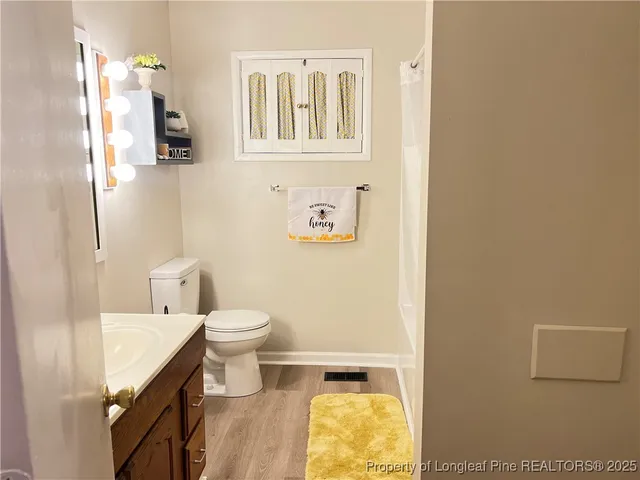 a bathroom with a granite countertop toilet and a sink
