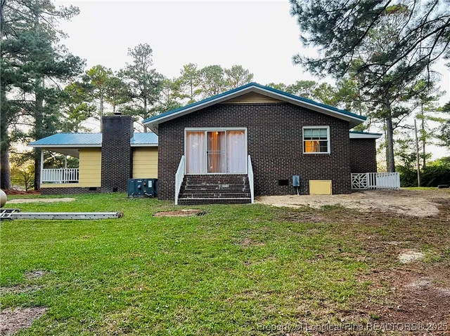 a front view of a house with a yard and trees