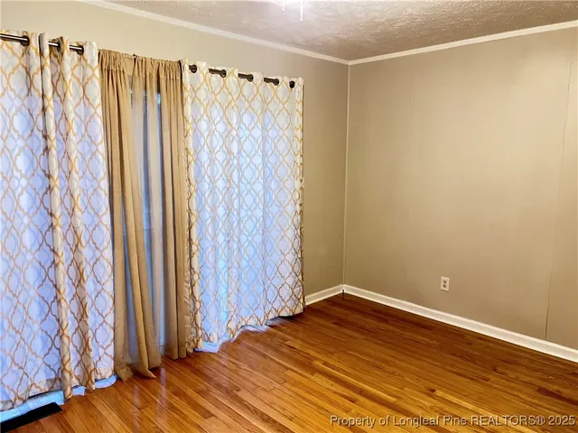 a view of a room with wooden floor and a curtain