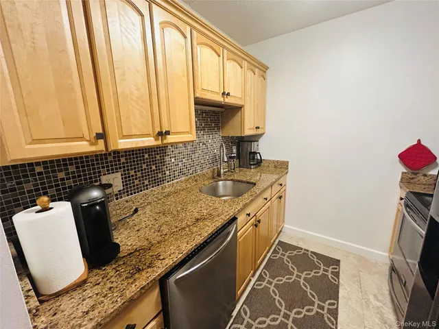 a kitchen with granite countertop a sink a stove and a microwave
