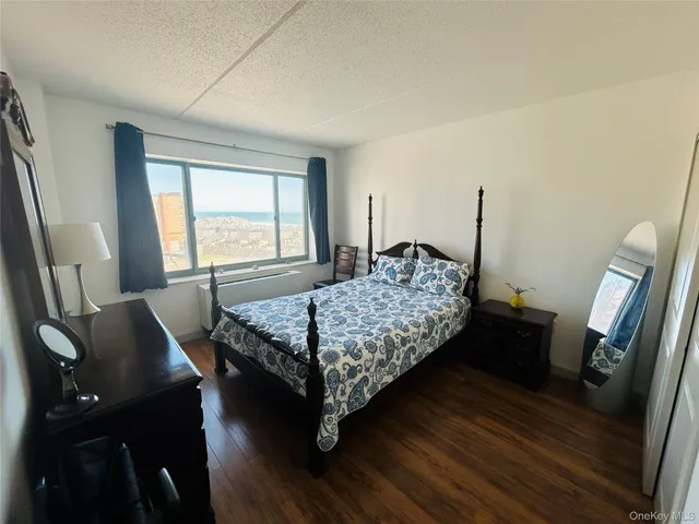 a bedroom with a bed window and wooden floor