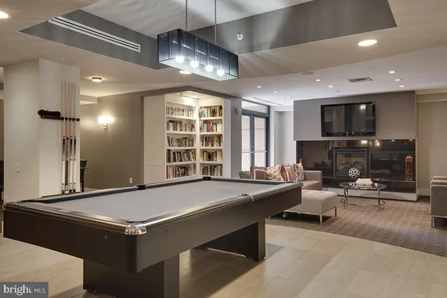 a living room with stainless steel appliances kitchen island granite countertop a stove and a sink