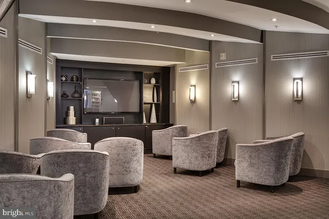 a living room with couches and a potted plant