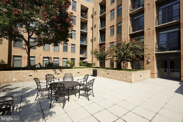 a view of a patio with couches table and chairs and potted plants