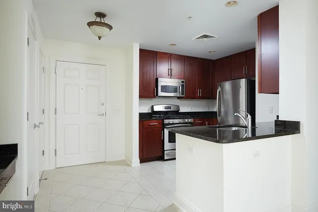 a kitchen with stainless steel appliances granite countertop a stove a refrigerator and a sink