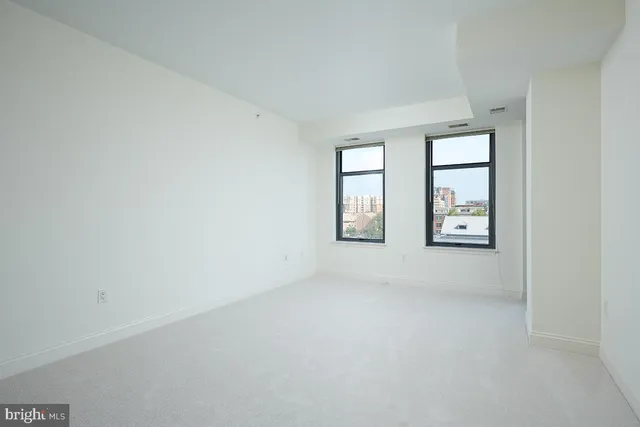 an empty room with windows and closet