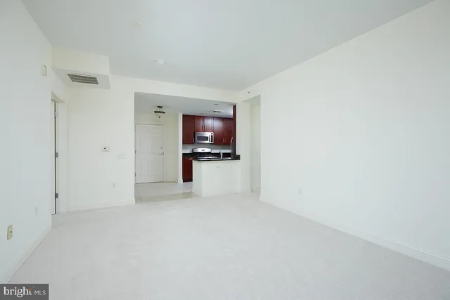 a view of empty room with a kitchen
