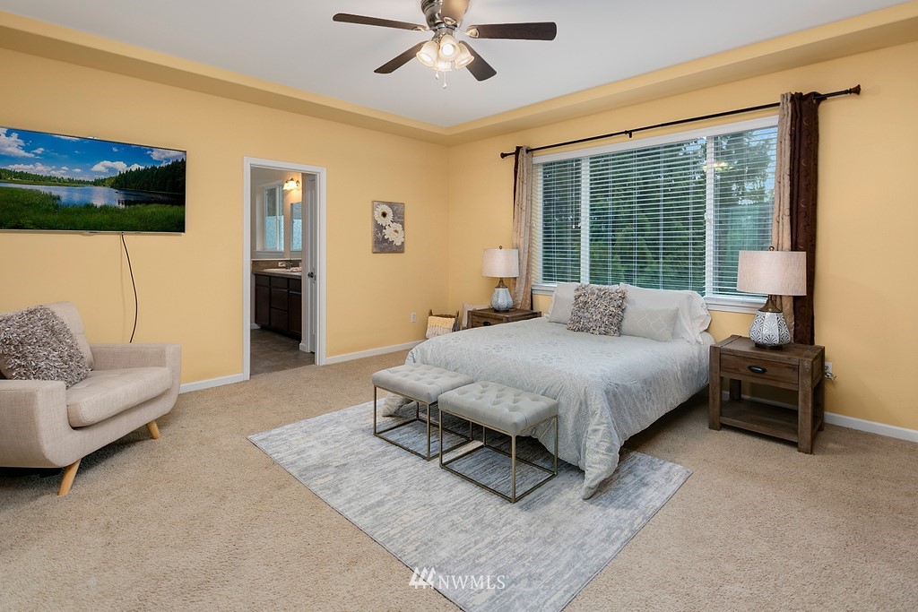 22214 151st Place Southeast Monroe, WA 98272 - Photo 21 of 28 a spacious bedroom with a bed a couch and a large window