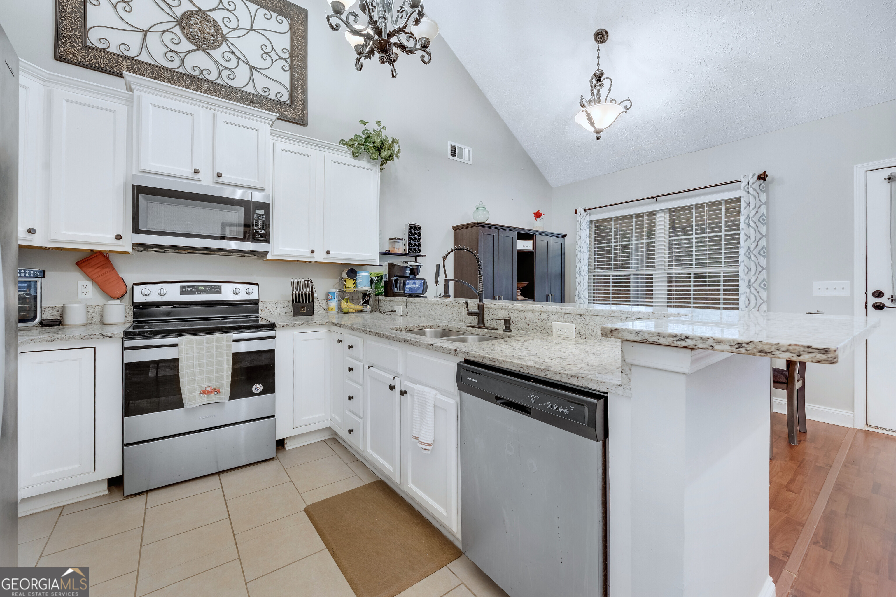 119 Cedar Ridge Drive LaGrange, GA 30241 - Photo 11 of 34 a kitchen with granite countertop a sink stainless steel appliances and white cabinets