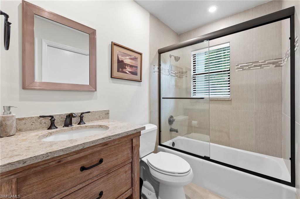 5120 Alpha Court Naples, FL 34105 - Photo 11 of 18 a bathroom with a granite countertop sink toilet and shower