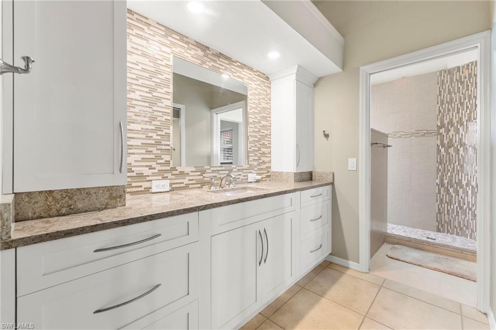 5120 Alpha Court Naples, FL 34105 - Photo 9 of 18 a bathroom with a granite countertop sink and a mirror