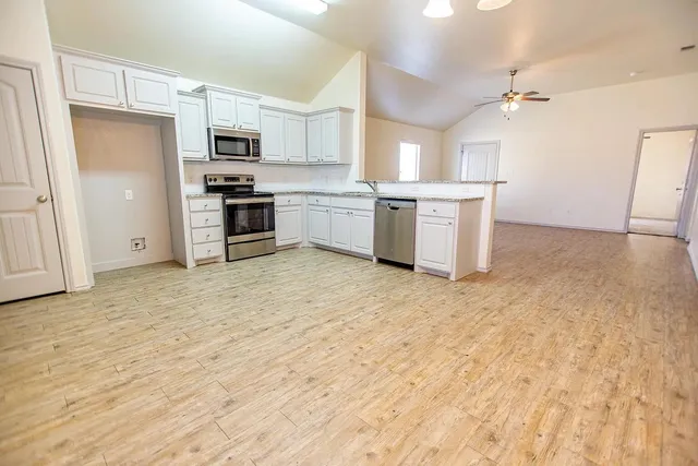 a kitchen with stainless steel appliances a refrigerator sink and cabinets