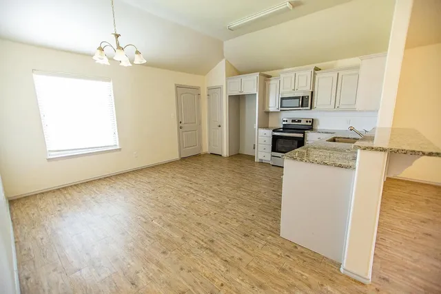 a kitchen with stainless steel appliances a refrigerator sink and microwave