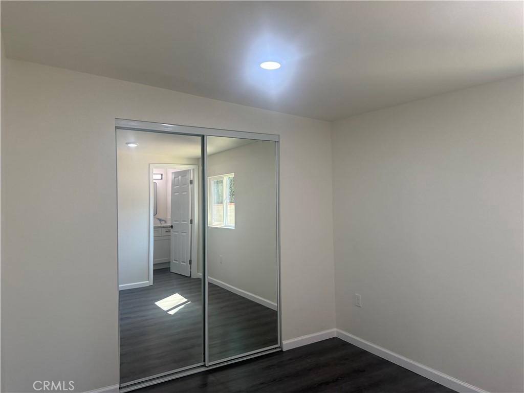 10337 Mull Avenue Riverside, CA 92505 - Photo 17 of 28 an empty room with wooden floor and mirror