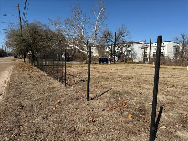 a view of a yard with wooden fence