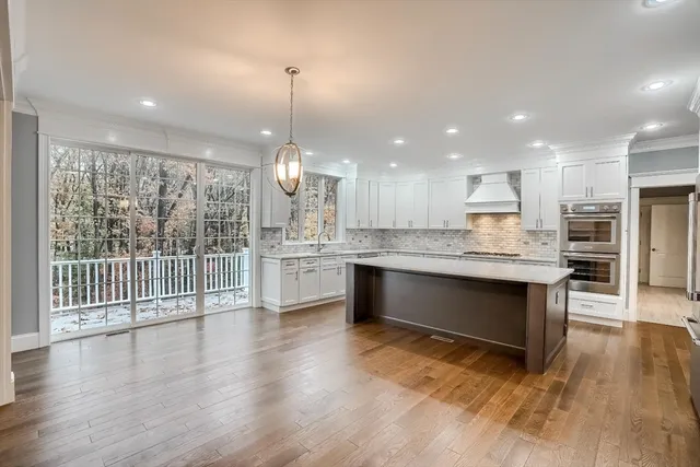 a open kitchen with kitchen island a sink stainless steel appliances and wooden floor