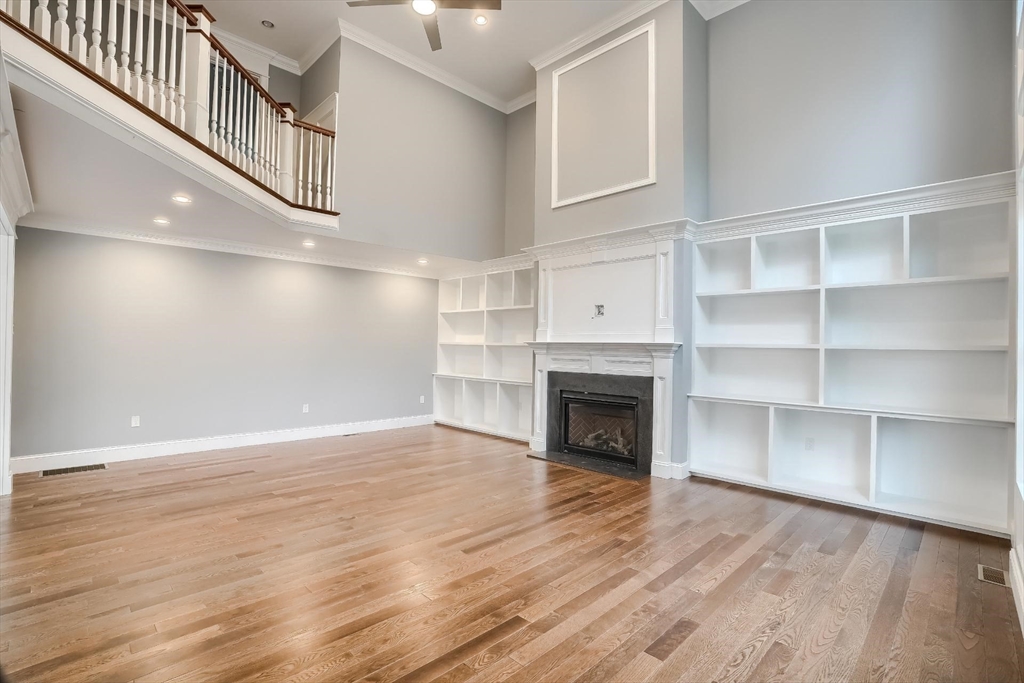 19 Stoney Brook Road Hopkinton, MA 01748 - Photo 9 of 41 a view of an empty room with wooden floor and a kitchen