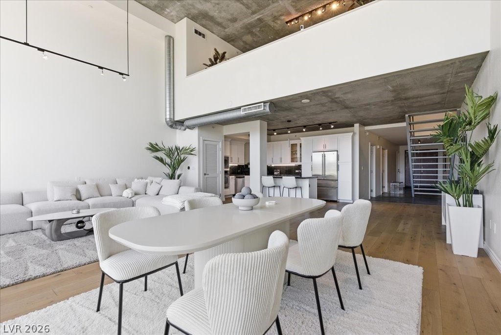 360 East Desert Inn Road, Unit 604 Las Vegas, NV 89109 - Photo 26 of 28 An open-concept living area boasts high ceilings and durable hardwood flooring, creating an airy and cohesive flow throughout the space.