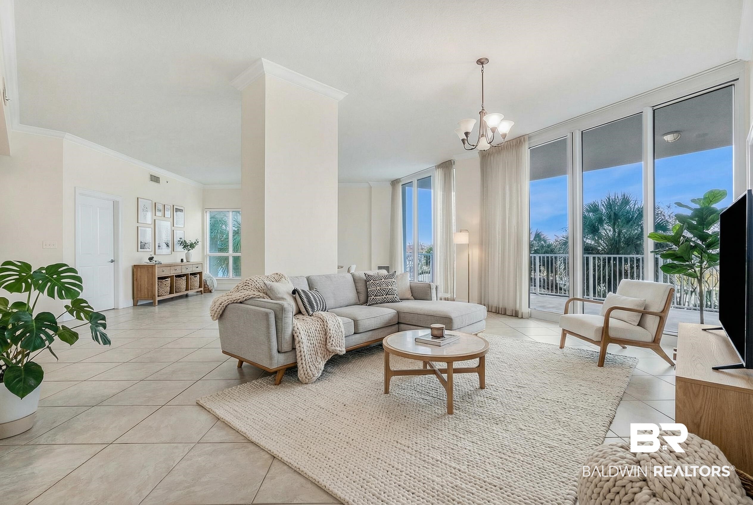 28250 Canal Road, Unit 106 Orange Beach, AL 36561 - Photo 45 of 50 Living room featuring expansive windows, a chandelier, light tile patterned floors, and ornamental molding