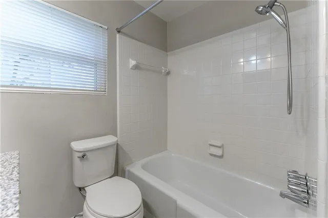 a white toilet sitting next to a bath tub