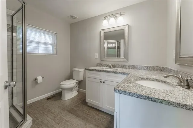 a bathroom with a granite countertop sink toilet and shower