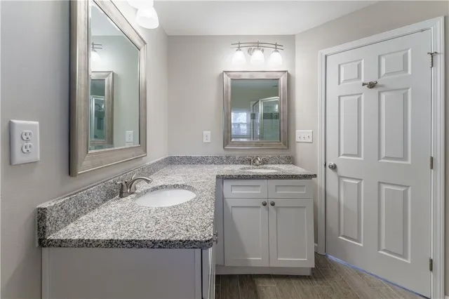 a bathroom with a granite countertop sink and a mirror