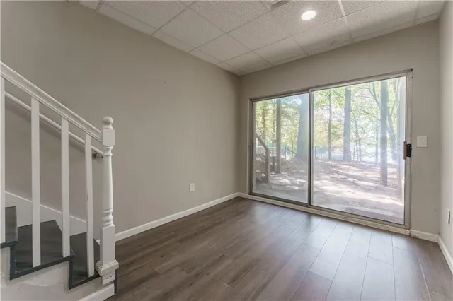 a view of an empty room with wooden floor and door