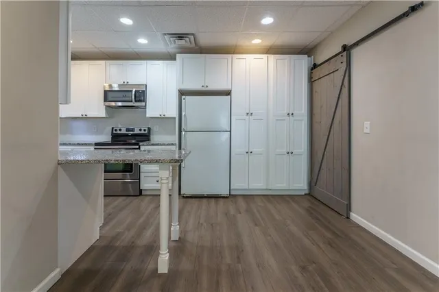 a kitchen with stainless steel appliances a refrigerator and a stove top oven