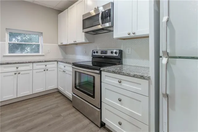 a kitchen with white cabinets and white appliances
