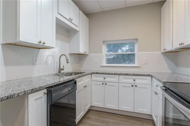 a kitchen with granite countertop white cabinets white stainless steel appliances and sink