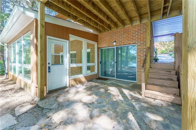 a view of a house with a large window and plants