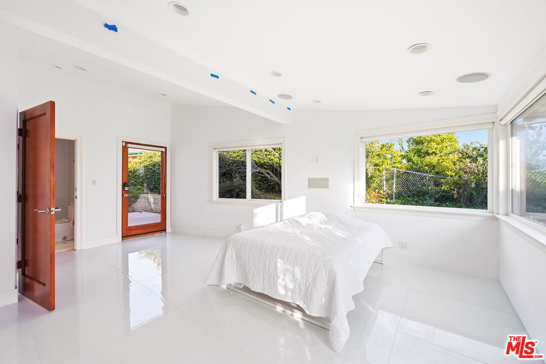 6246 Trancas Canyon Road Malibu, CA 90265 - Photo 13 of 23 a bedroom with a bed and a large window