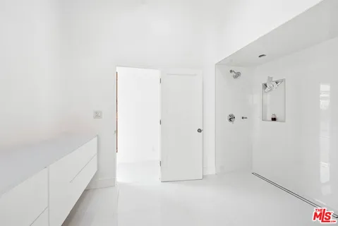 a bathroom with a sink a mirror and a potted plant