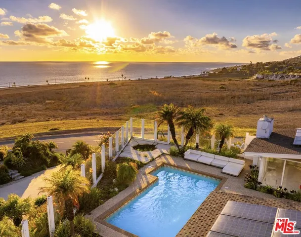 a view of swimming pool with outdoor seating and plants