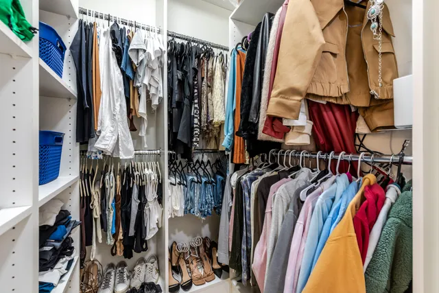 a view of walk in closet with clothes and shoes