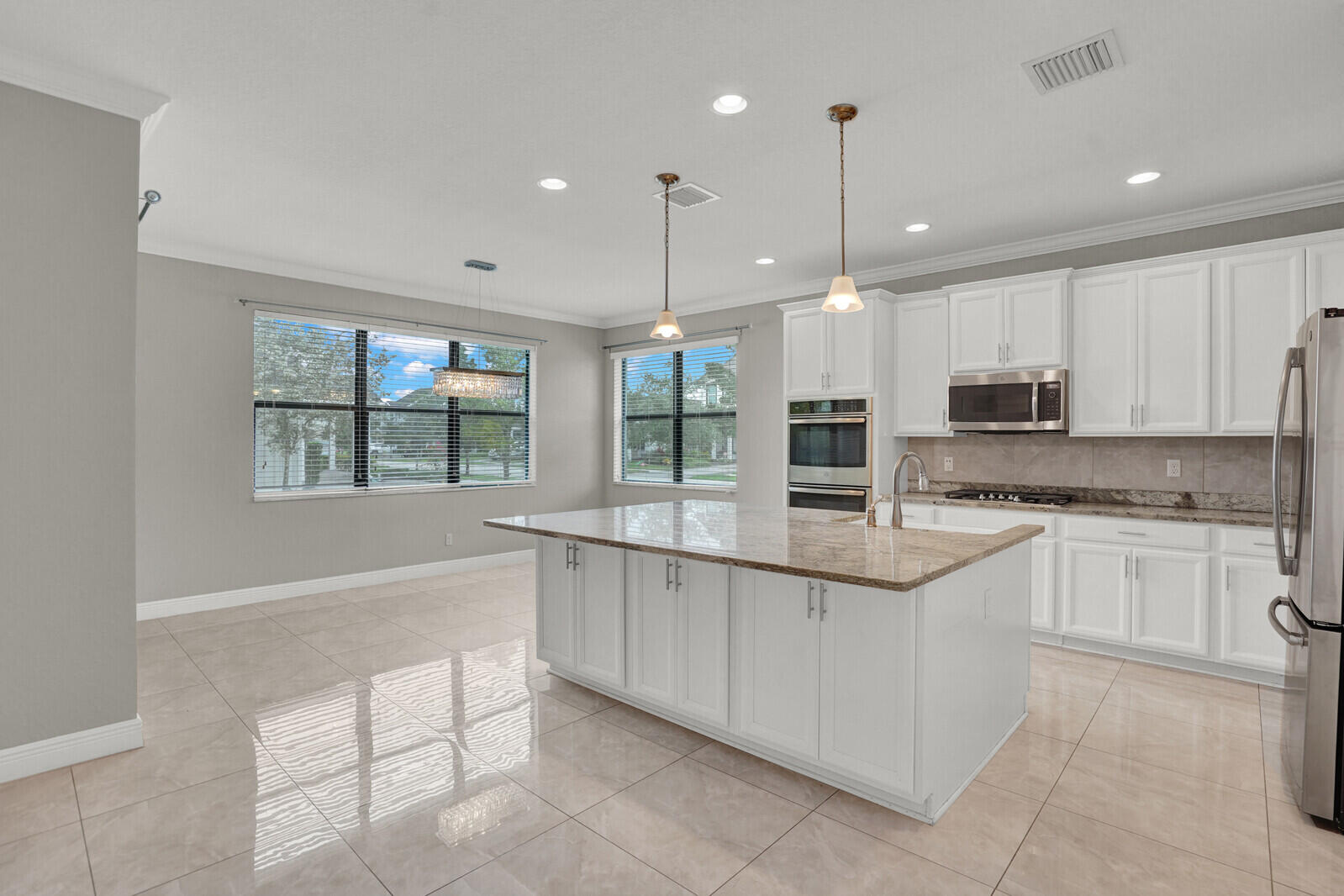 19739 Wheelbarrow Bend Loxahatchee, FL 33470 - Photo 12 of 57 a kitchen with stainless steel appliances granite countertop a stove and cabinets
