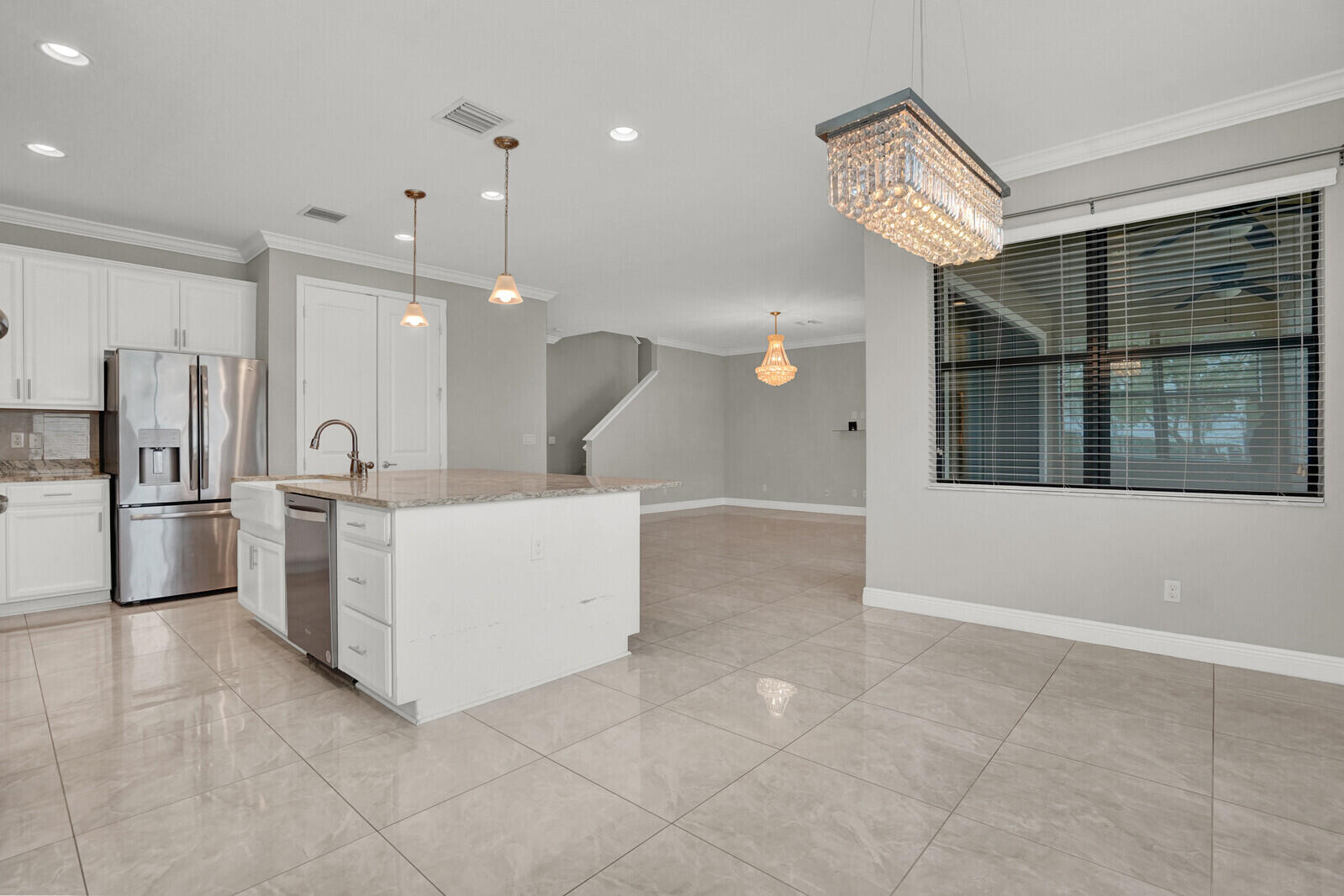 19739 Wheelbarrow Bend Loxahatchee, FL 33470 - Photo 16 of 57 a large white kitchen with a large window cabinets and stainless steel appliances