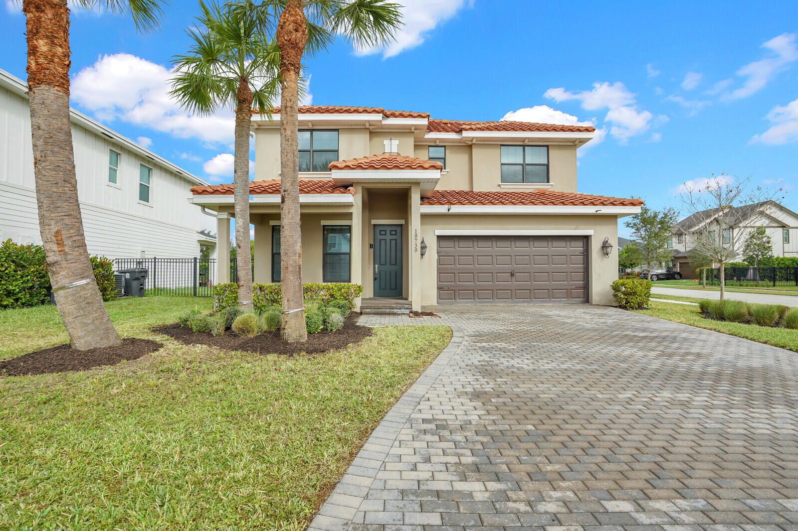 19739 Wheelbarrow Bend Loxahatchee, FL 33470 - Photo 2 of 57 a front view of a house with a yard and potted plants