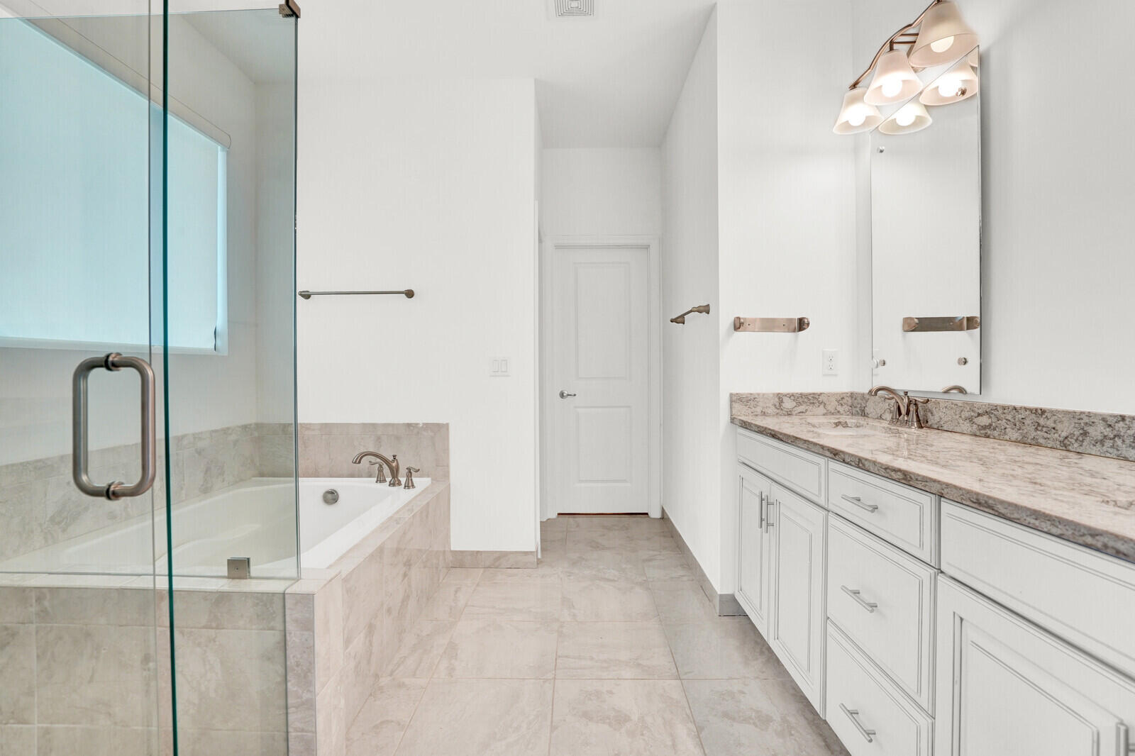19739 Wheelbarrow Bend Loxahatchee, FL 33470 - Photo 26 of 57 a spacious bathroom with a tub sink and mirror