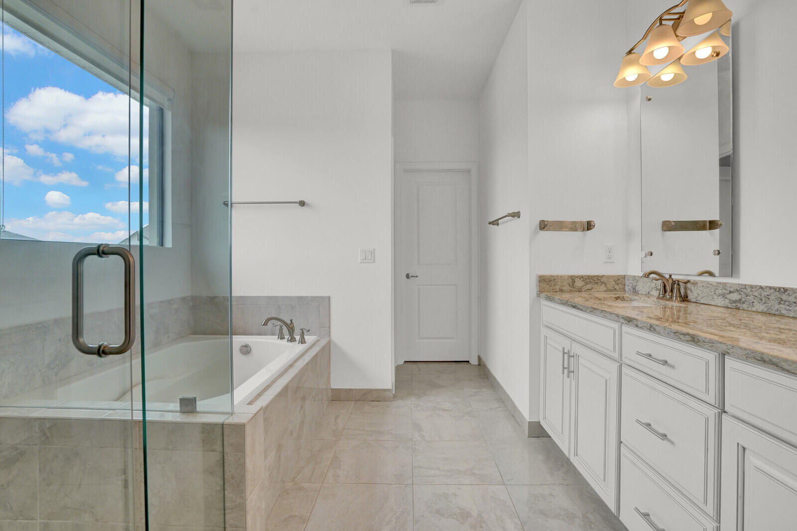 19739 Wheelbarrow Bend Loxahatchee, FL 33470 - Photo 28 of 57 a spacious bathroom with a granite countertop tub sink and mirror