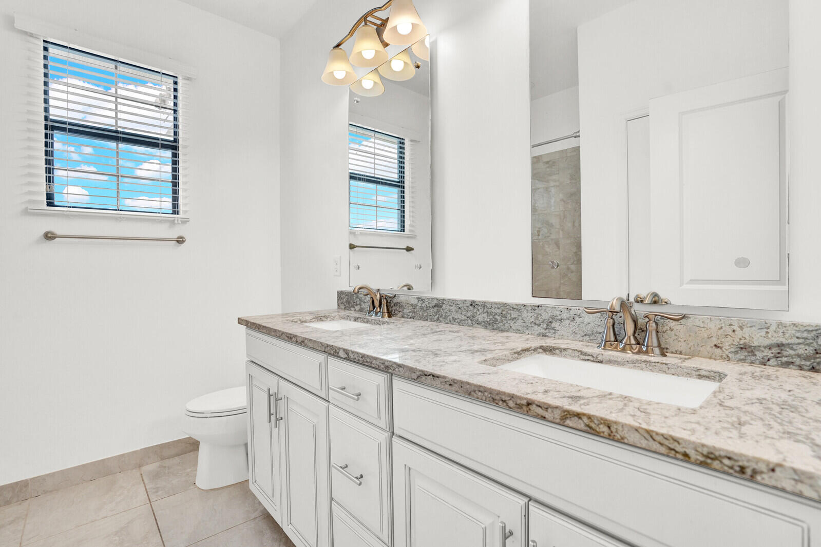 19739 Wheelbarrow Bend Loxahatchee, FL 33470 - Photo 32 of 57 a bathroom with a granite countertop sink a toilet and a mirror