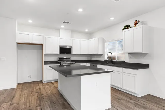 a kitchen with stainless steel appliances granite countertop a sink stove and refrigerator