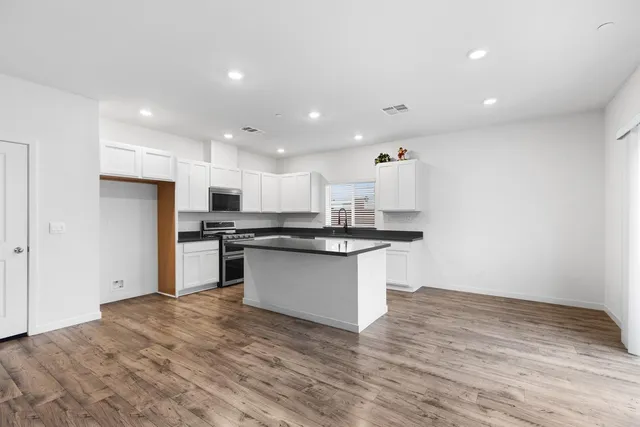 a kitchen with a refrigerator and white cabinets