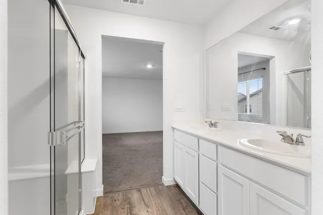 a bathroom with a double vanity sink and mirror