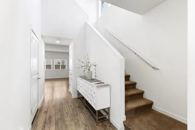 a view of a hallway with wooden floor and staircase