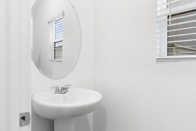 a bathroom with a sink a mirror and a window
