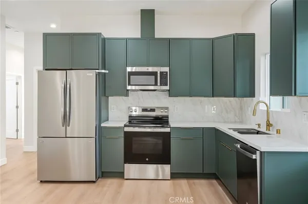 a kitchen with stainless steel appliances granite countertop a refrigerator stove and microwave