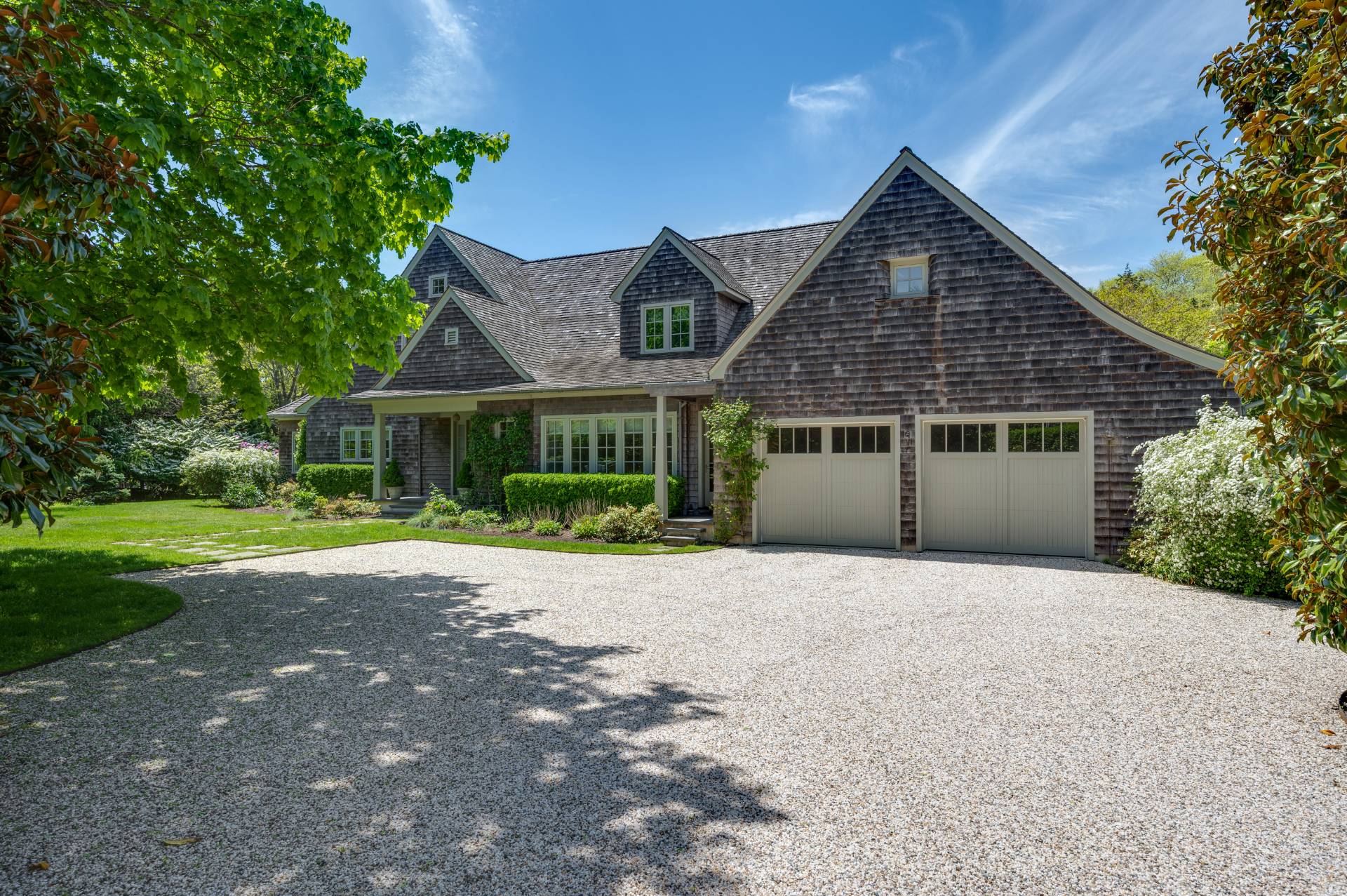 Undisclosed Address Remsenburg, NY 11960 - Photo 2 of 50 a front view of a house with a garden and trees