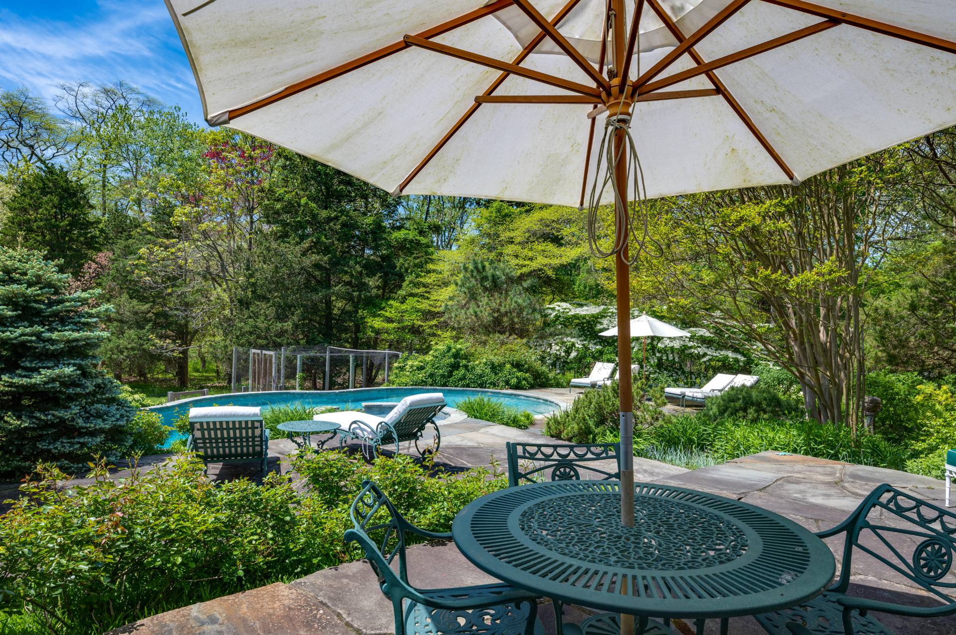 Undisclosed Address Remsenburg, NY 11960 - Photo 35 of 50 a backyard of a house with table and chairs under an umbrella